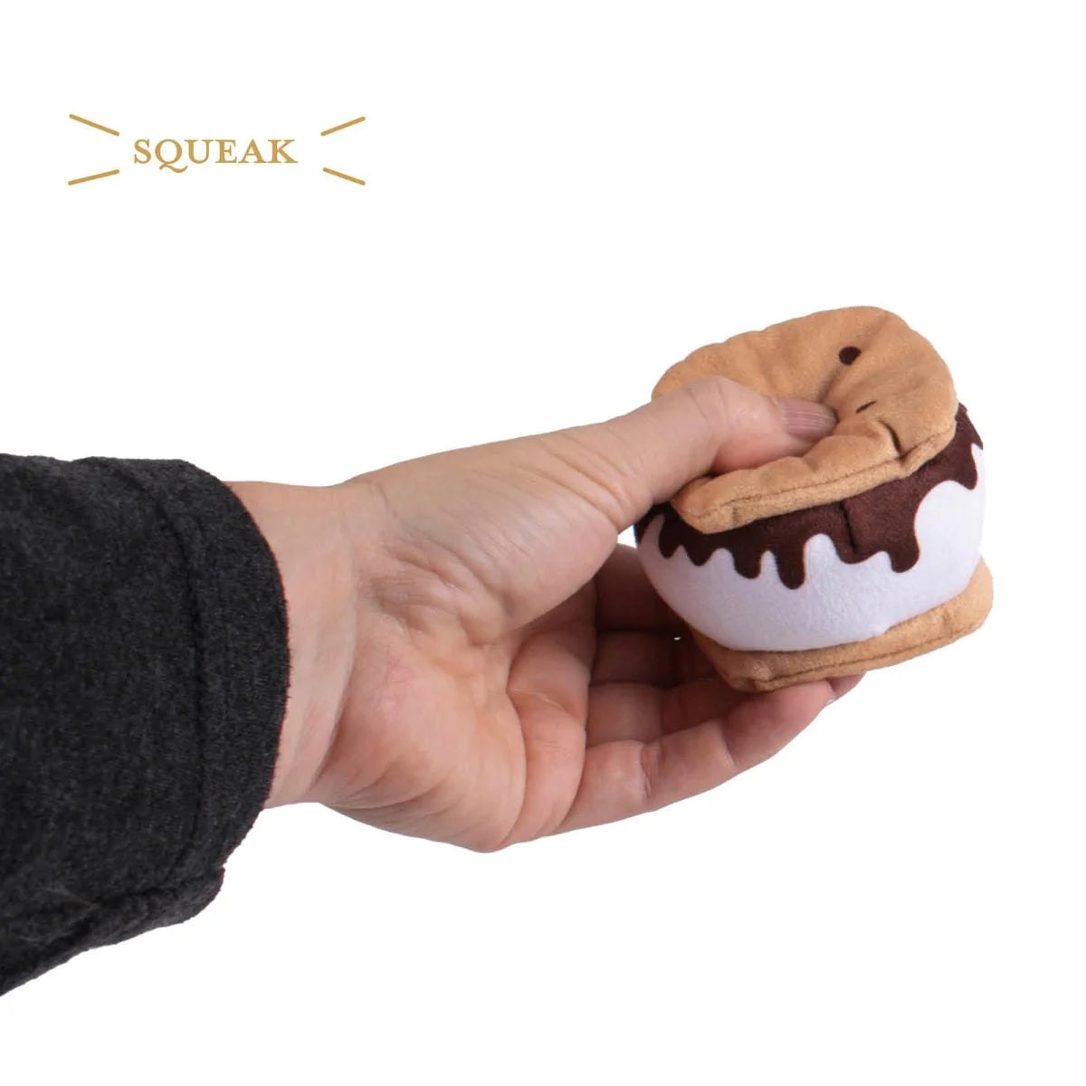 Hand holding a plush ice cream toy with 'Squeak' branding on a white background
