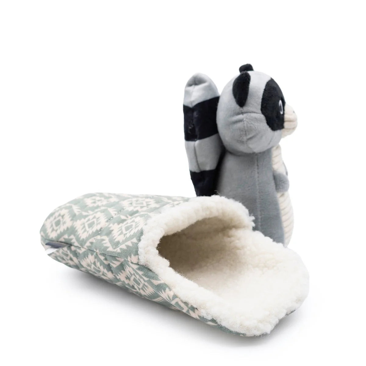 Plush toy shaped like a snake with a raccoon head on a floral-patterned cushion.