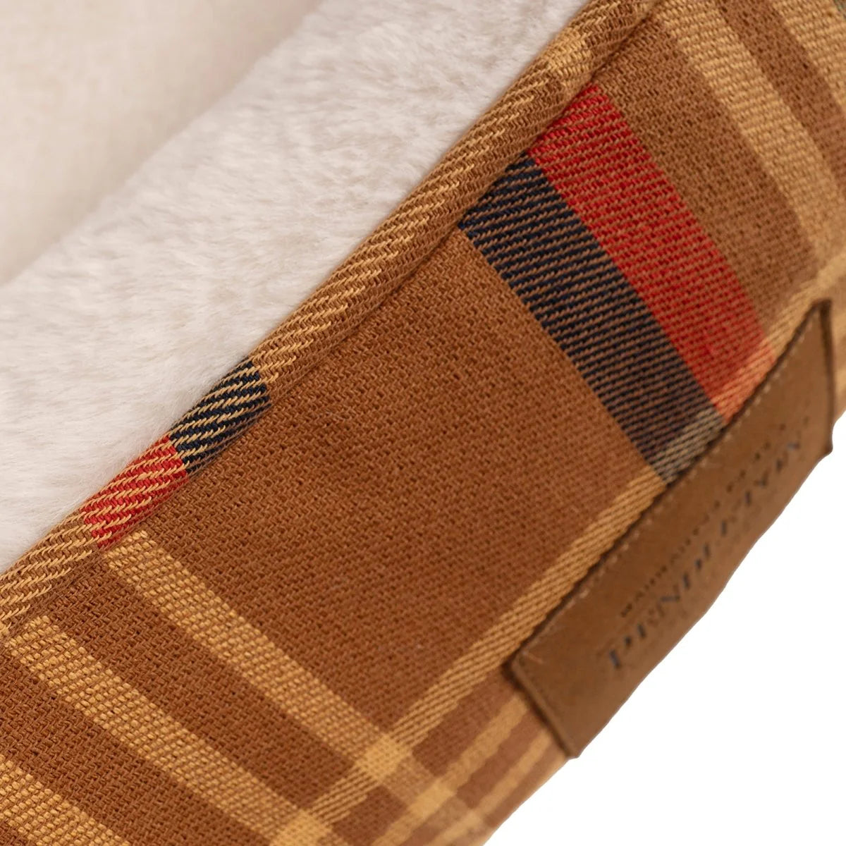 Close-up of a brown plaid fabric with a visible brand label on a white background