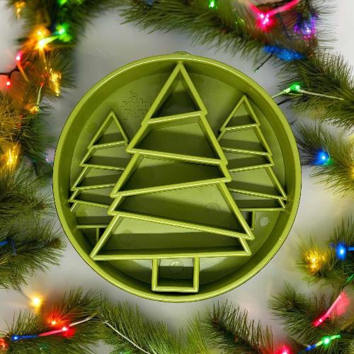 Green Christmas tree-shaped cookie cutter surrounded by festive lights and greenery